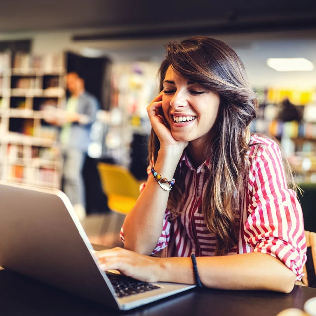 Weibliche Studentin bei der Arbeit am Laptop