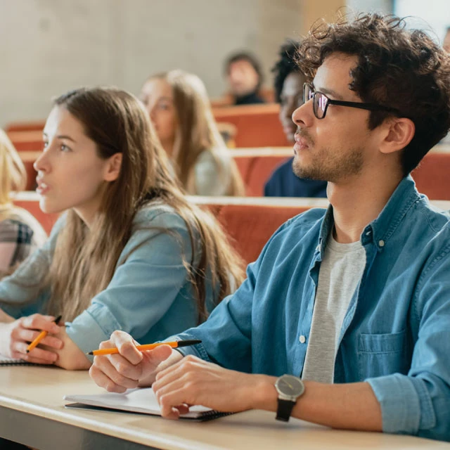 Junge Studenten hören interessiert in einer Vorlesung zu